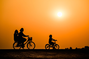 Fototapeta na wymiar Silhouette girl cycling on sunset background