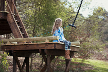 Little Girl Sitting on a Swing Platform