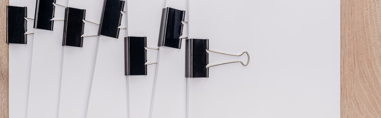 panoramic shot of stacks of blank paper with metal paper clips