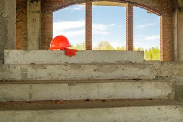 A pair of gloves and a Mason's helmet at the construction.