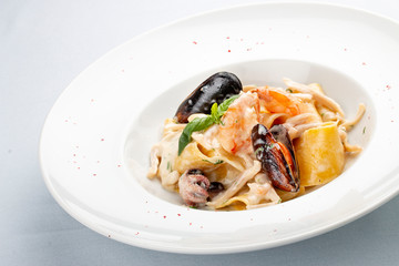 Fettuccine with seafood, shrimp, mussels and octopus. On white background