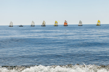 sailboats on the horizon are sailing on the blue sea