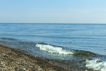 sailboats on the horizon are sailing on the blue sea