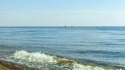 sailboats on the horizon are sailing on the blue sea