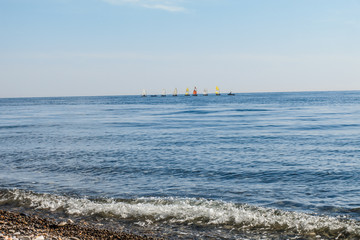 sailboats on the horizon are sailing on the blue sea