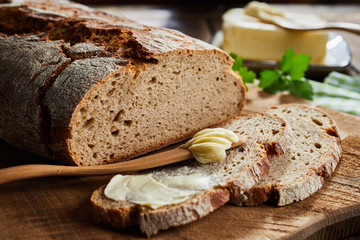 Buttered slice of rye bread with crusty loaf