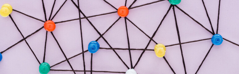 panoramic shot of colorful push pins connected with strings Isolated On pink, network concept