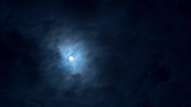 25fps4k Timelapse. Full moon in night sky behind clowds 