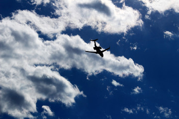A jet airliner flying under the sun shining in the sky