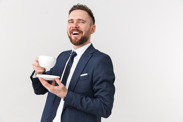Happy businessman posing isolated over white wall background drinking coffee.