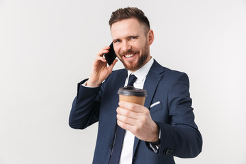 Happy businessman posing isolated over white wall background drinking coffee talking by phone.