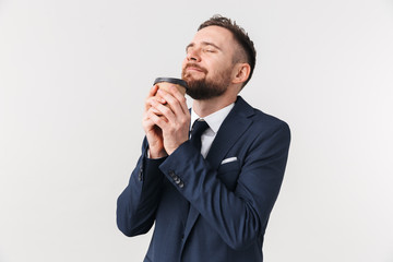 Businessman posing isolated over white wall background drinking coffee.