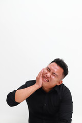 Young man suffering from toothache on white background, closeup