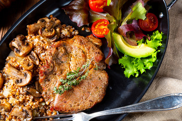 Pork steak with mushrooms and buckwheat groats and mango salad