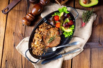 Pork steak with mushrooms and buckwheat groats and mango salad