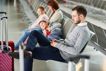 Familie mit zwei Kindern wartet in der Flughafen Ruhezone