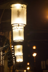 Fototapeta na wymiar Light of lanterns on a dark street