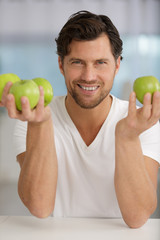 young man holding green apples