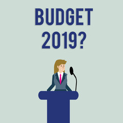 Text sign showing Budget 2019 Question. Business photo text estimate of income and expenditure for next year Businesswoman Standing Behind Podium Rostrum Speaking on Wireless Microphone