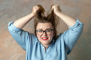 Portrait of attractive plus size woman having anger emotions, expressing hopelessness and irritation isolated over colored background.  Stout woman shouting with rage. Concept of emotions.