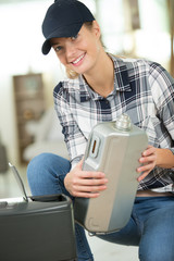 smiling casual woman holding a can of engine oil