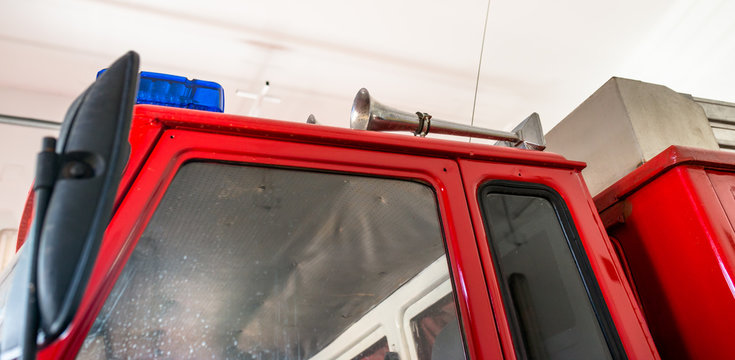 Blue warning signals and a siren placed on the roof of a fire truck.