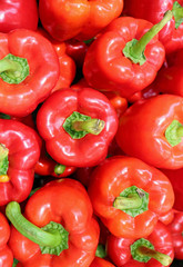 Vertical Photo of Heap of Fresh Ripe Red Bell Peppers with Green Stem Top View