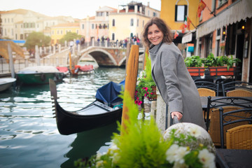 Fototapeta na wymiar Young woman in Venice, Italy. Girl in Venice on gondolas and street canal background.