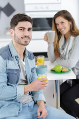 happy couple drinking orange juice in the kitchen