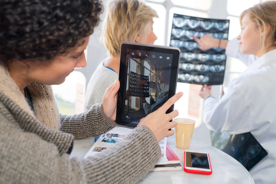 woman taking a picture of xray with tablet
