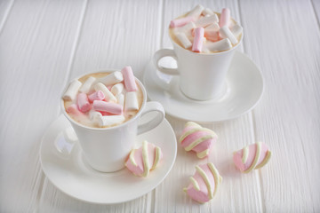 Morning cappuccino, two cups with marshmallows on a white background. Pastel colors. Look from above.