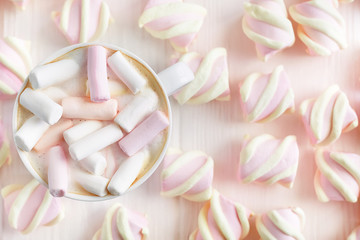 Cappuccino with marshmallows in a white cup on the background of marshmallows. Top view