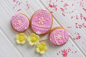 Sweets, pastry to the Easter table. Pink easter gingerbread in the shape of an egg, handmade gingerbread. White background top view