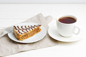 Piece of homemade pie and cup of tea on white wooden table