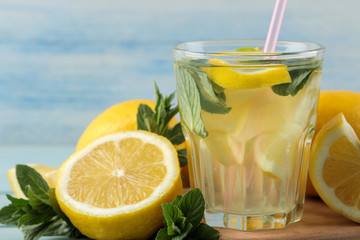 Homemade lemonade with mint and lemon in plastic glasses on a blue wooden background. Refreshing lemonade drink.