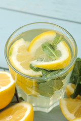 Homemade lemonade with mint and lemon in plastic glasses on a blue wooden background. Refreshing lemonade drink. close-up