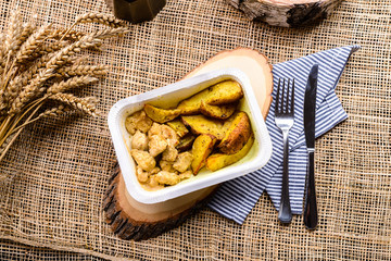 food delivery homemade potatoes in a box on rustic background