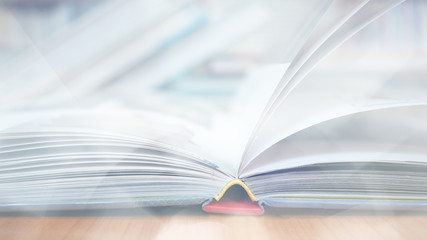 Blurred image, open book page on wood desk in the library room for business and  education background, back to school concept