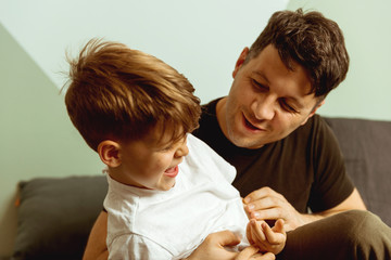 Smiling son playing with his father 