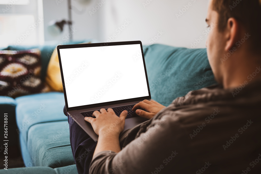 Poster man using laptop blank screen while sitting on sofa