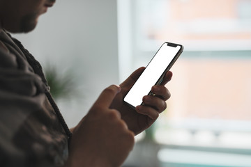 Man using smartphone blank screen in home interior