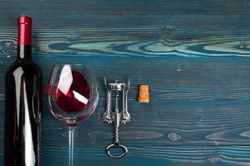 Bottle of wine and cork and corkscrew on wooden table
