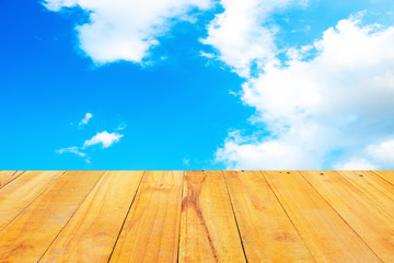 Old Wooden table with blue sky white cloud background.