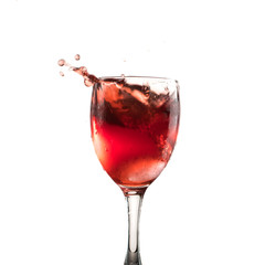 A glass of red wine on a white or black background with splashes.