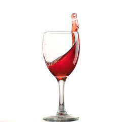 A glass of red wine on a white or black background with splashes.