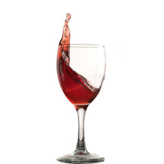A glass of red wine on a white or black background with splashes.