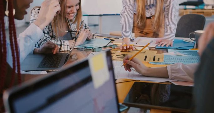Teamwork at multiethnic workplace. Close-up shot, hands of business people working together at modern office meeting.