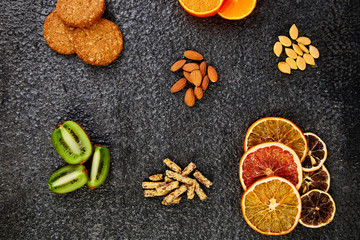 Fototapeta na wymiar Healthy snacks - variety oat granola bar, rice crips, almond, kiwi, dried orange