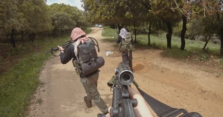 POV footage of armed terrorists patrolling a forest area