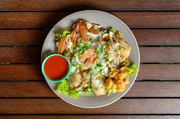 Stir-fried rice noodle with chicken, squid, fry egg and lettuce